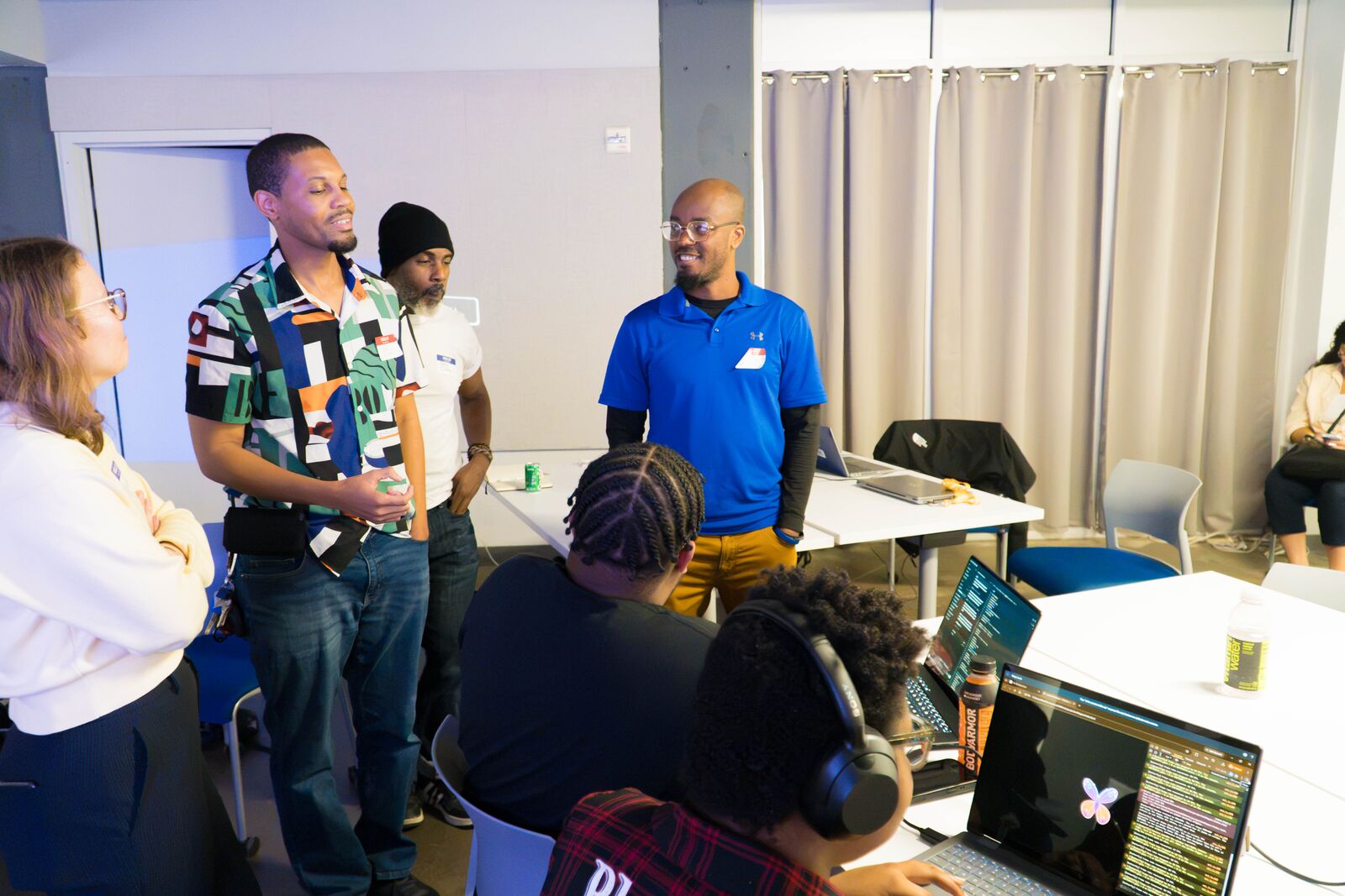 Attendees stand and talk while others keep working at their laptops.
